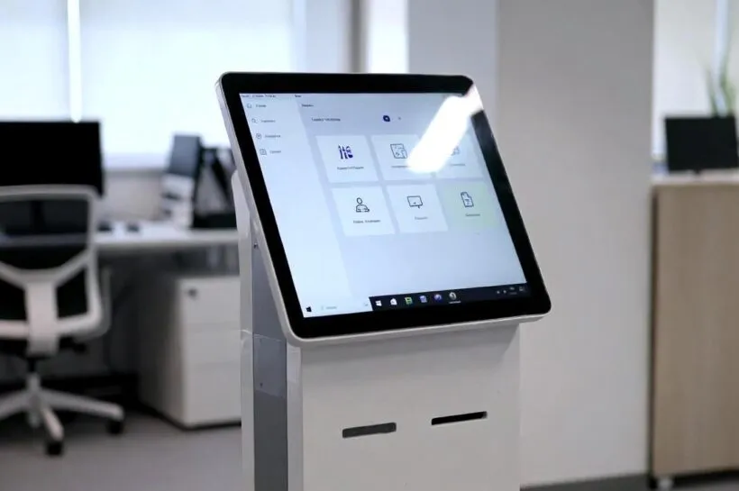Totem de autoatendimento moderno com tela touch em ambiente corporativo, representando a tendência crescente de soluções de atendimento automático nas empresas brasileiras.