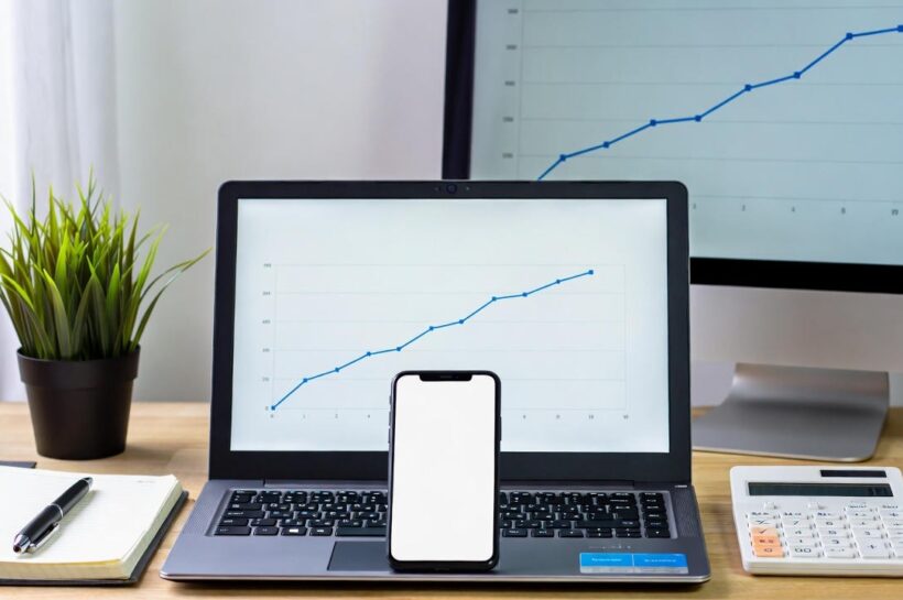 IA para pequenos negócios: mesa de trabalho organizada com notebook, celular e gráficos de crescimento exibidos nas telas, representando como a inteligência artificial ajuda empreendedores a automatizar tarefas, analisar dados e aumentar resultados de forma simples e acessível.