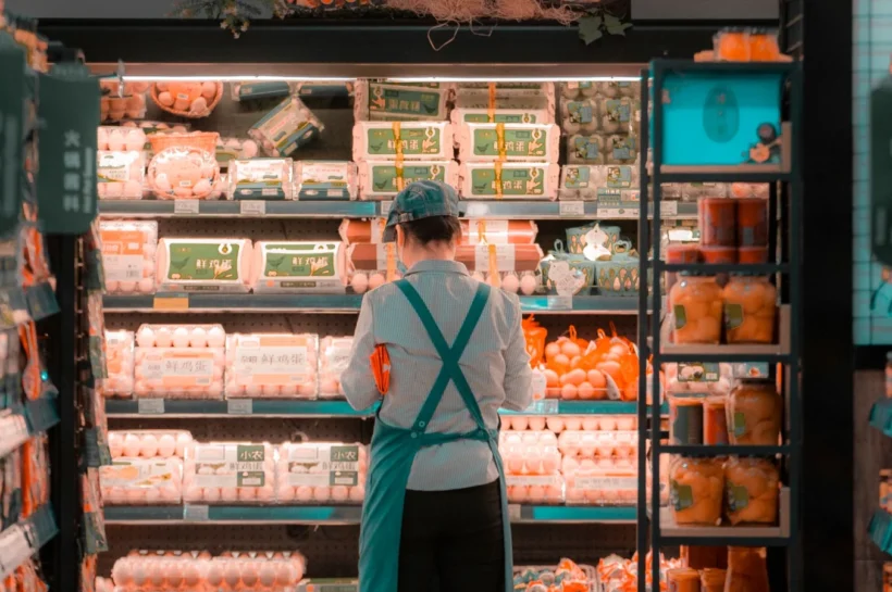 Funcionária de supermercado organizando produtos nas prateleiras