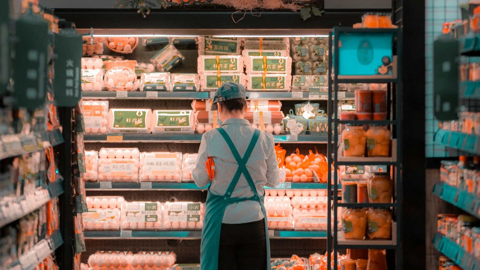 Funcionária de supermercado organizando produtos nas prateleiras