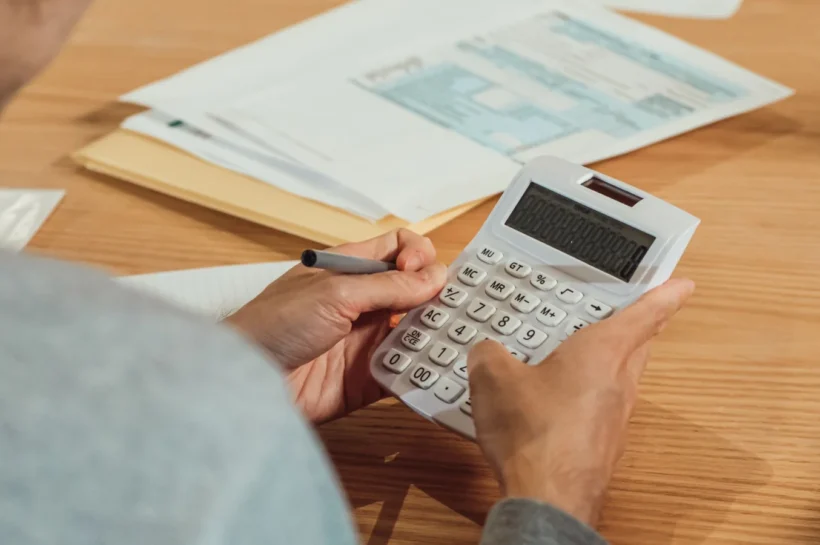 Cálculo de margem de contribuição com calculadora e documentos financeiros