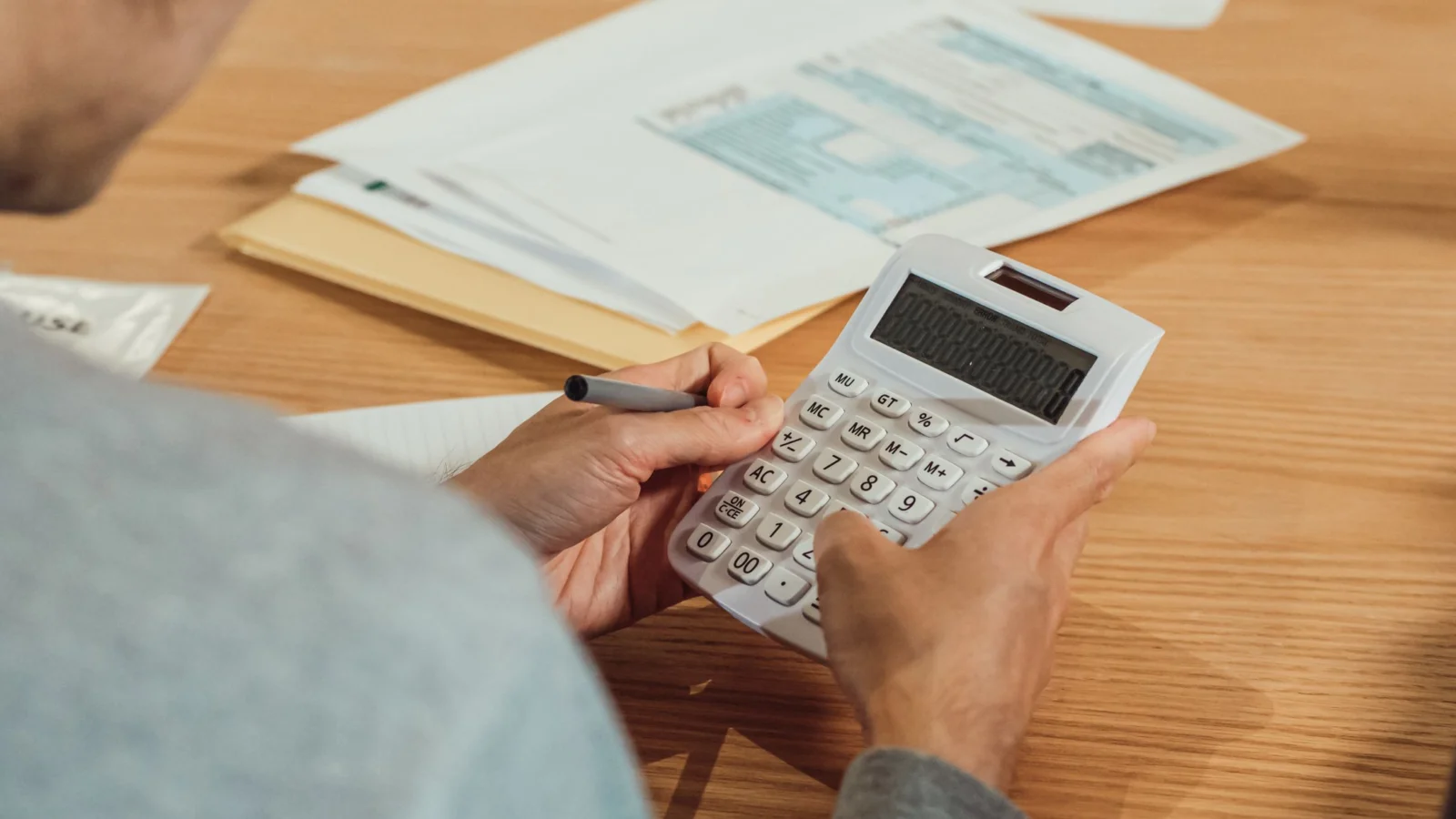 Cálculo de margem de contribuição com calculadora e documentos financeiros
