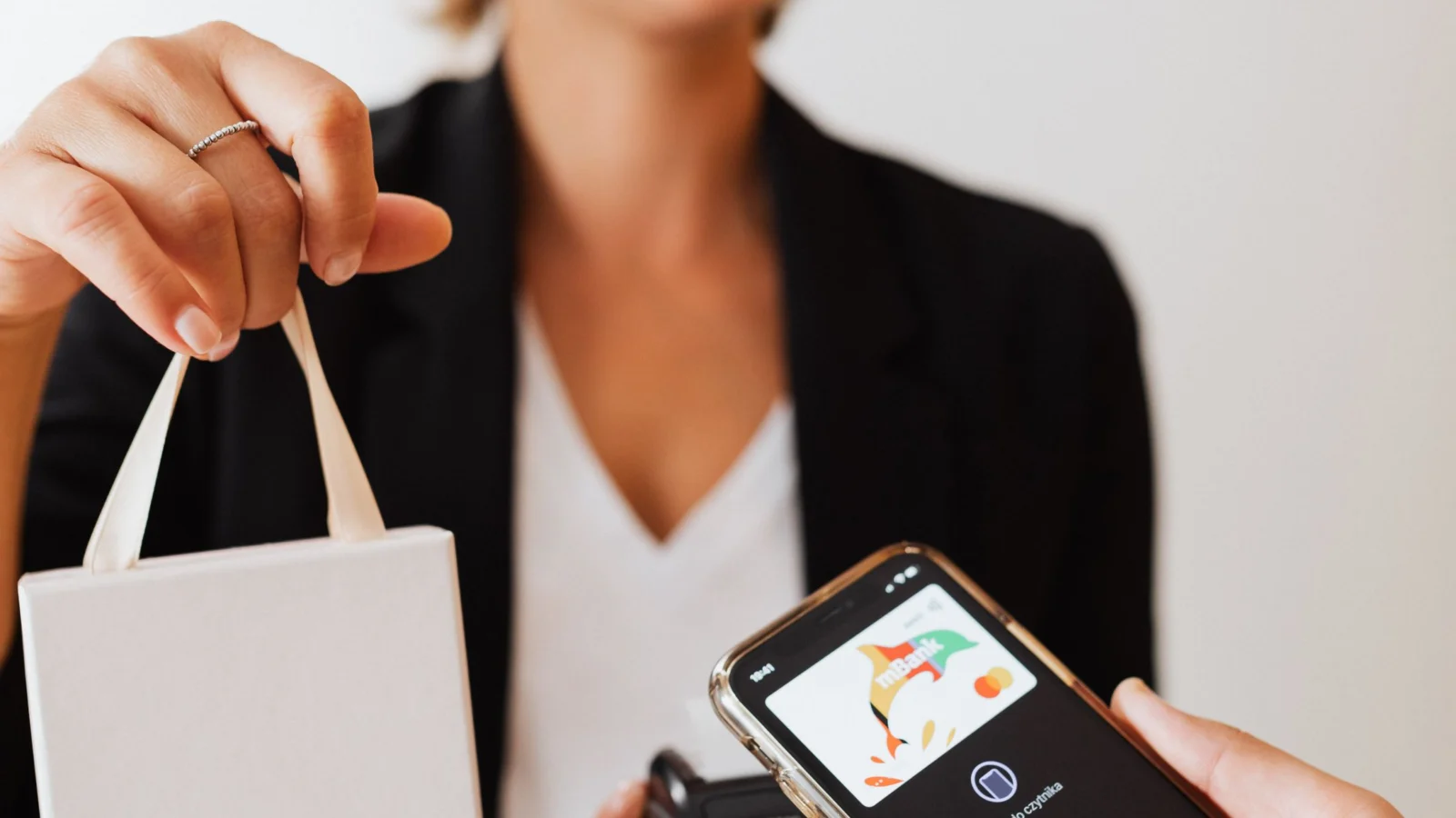 Prevenção a fraudes em pagamentos: cliente usando celular e máquina de pagamento em comércio