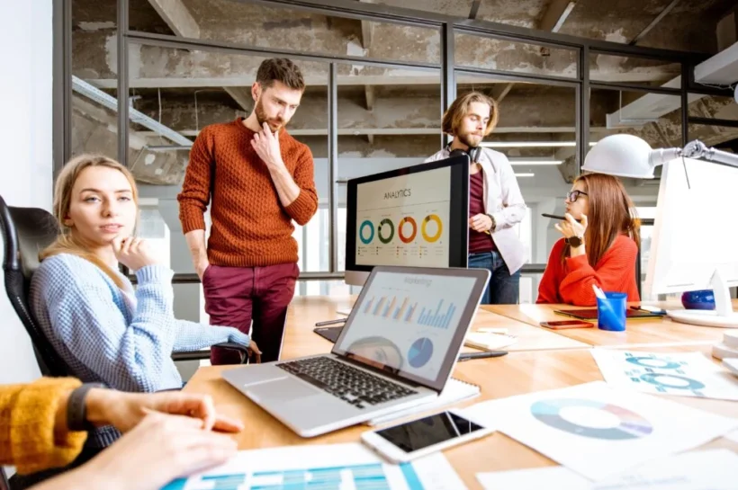 Equipe analisa gráficos e ferramentas de gestão em uma mesa de escritório